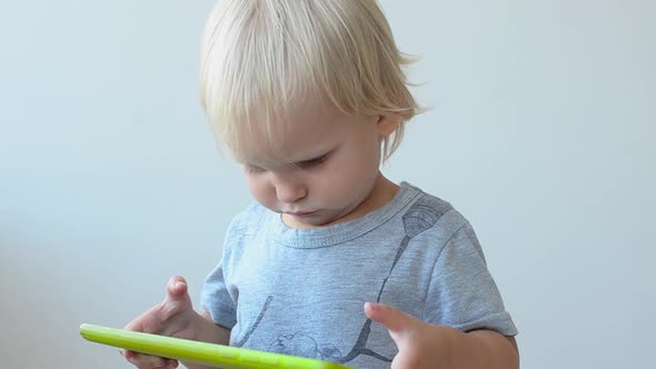 Little Girl Plays on the Tablet PC