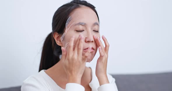 Woman apply paper mask on face at home