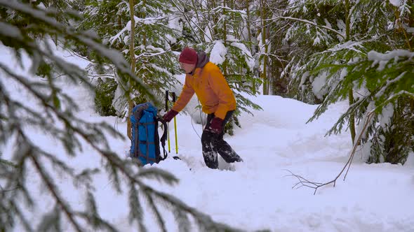 Backpacker Hiking in Winter Forest