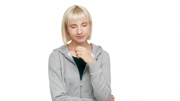 Portrait of Beautiful Blond Woman with Bob Haircut and Bangs Posing with Eyes Closed Giving Air Kiss