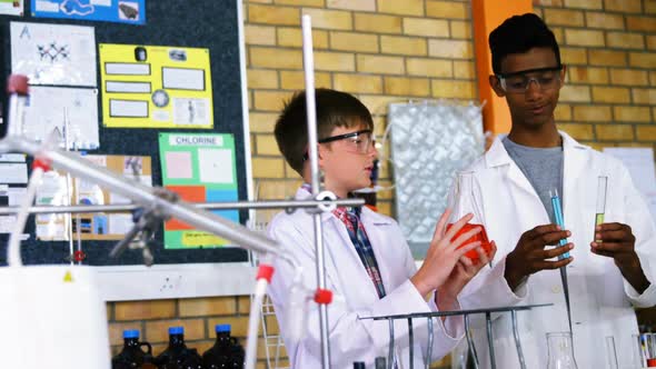 Attentive school kids doing a chemical experiment in laboratory