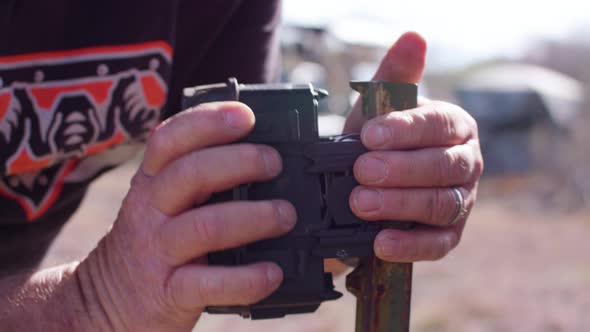 Man putting a trail camera on a post