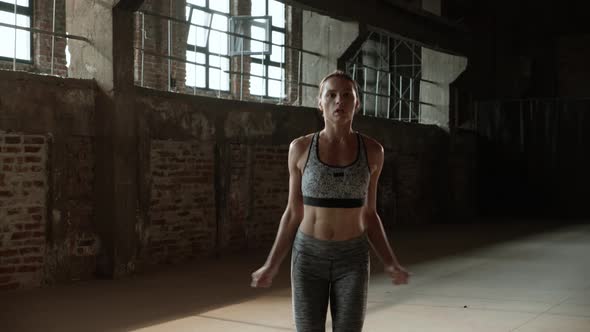 Fit woman doing jumping jack exercise at fitness gym