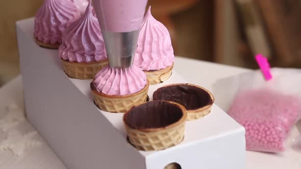 A Woman Makes Marshmallows In Waffle Cones. With A Pastry Bag.