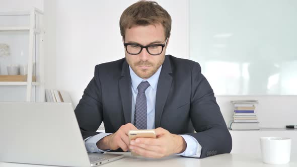 Businessman Using Smartphone at Work