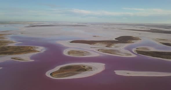Drone flying over small sand islands of pink Lake Tyrrell, Australia