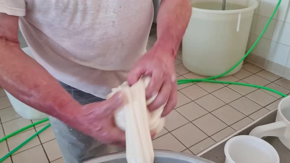 Cheesemaker making  stretched curd  to produce mozzarella and caciocavallo in cheese factory