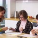 Two Girls with Down Syndrome Draw at the Kitchen Next to the Teacher or Mother Together Slow Motion - VideoHive Item for Sale