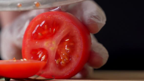 Human Hands Cut Tomatoes on a Cutting Board