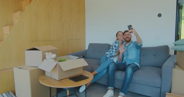 Panning Waist-up Shot of Pleased Smiling Caucasian Husband and Wife Making Memorable Selfies on