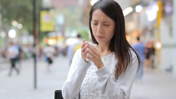 Woman sneezing at the outdoor 