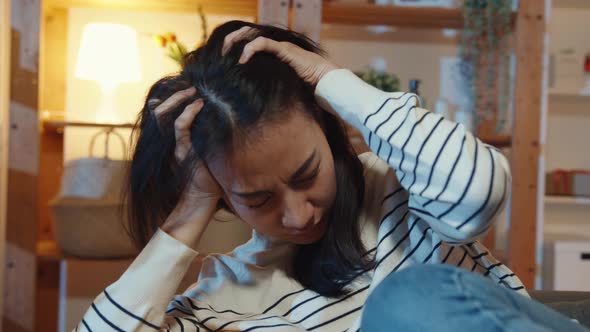 Asia lady suffering from insomnia sit at sofa in living room at house night with feel lonely.