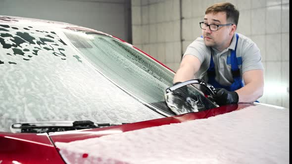 Modern Washing with Foam and Highpressure Water of a Red Car