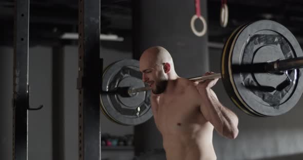 Strong Sportsman Doing Squats with Barbell