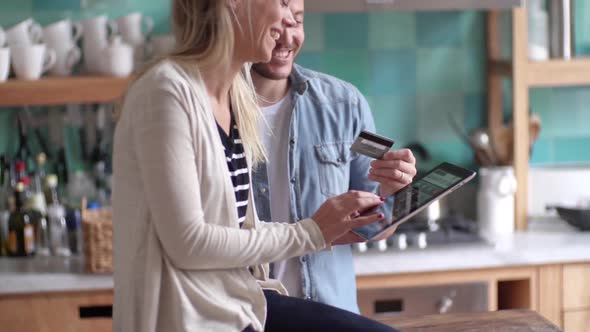 Couple shopping online with digital tablet at home