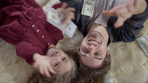 Rich Cheerful Father and Daughter Catching Dollars Falling