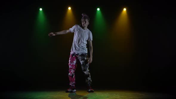 Professional Young Hip-hop Dancer, Dancing in Dark Studio in the Green and Yellow Fog. Hip Hop