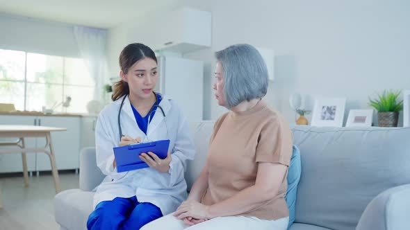 Asian caregiver psychology doctor examine, advise and consult to senior older woman patient at home.