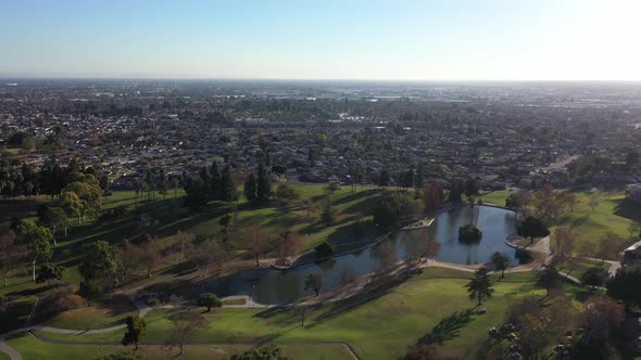 Drone shot flying away from the lake at the La Mirada Regional Park.