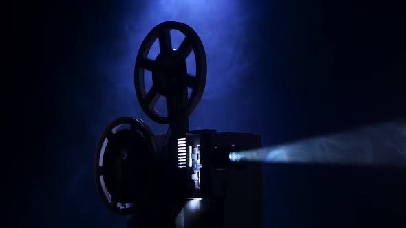 Projection Rays. Film Projector Turns Film in Smoky Dark Studio