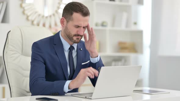 Stressed Businessman Having Headache in Office 