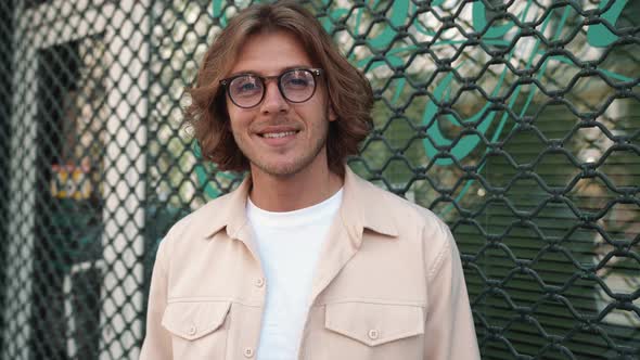 Positive blond man in eyeglasses looking at the camera