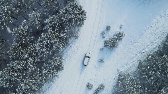 Aerial Top View From Drone of Suv Vehicle Driving on Snowy Ice Road Exploring Local Landscapes in