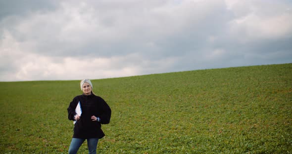 Female Farmer Examining Oilseed Rape Field