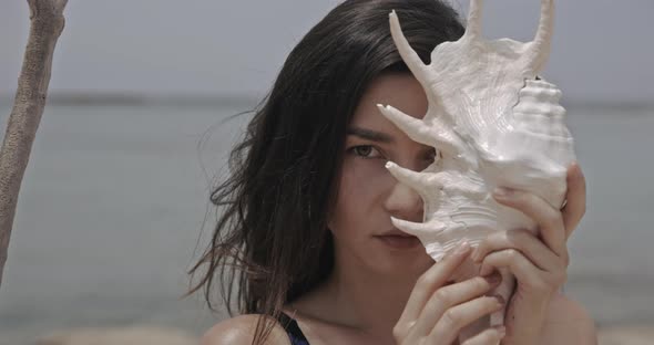 Half Portrait of Lady Listening the Seashell Filmed on Cinema Camera Young Attractive Woman Walking