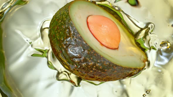 Super Slow Motion Shot of Fresh Avocado Falling and Splashing Into Oil at 1000 Fps