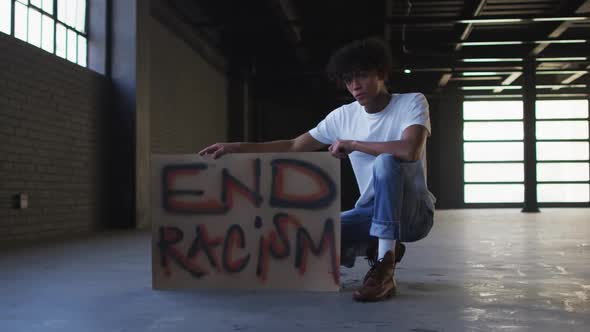 Portrait of african american man holding protest placard in empty parking garage