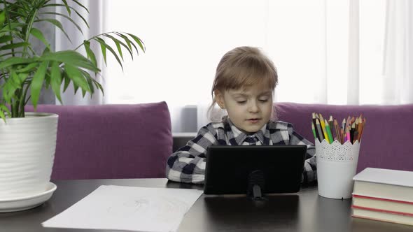 Girl Studying Online Homework Using Digital Tablet Computer. Distance Education