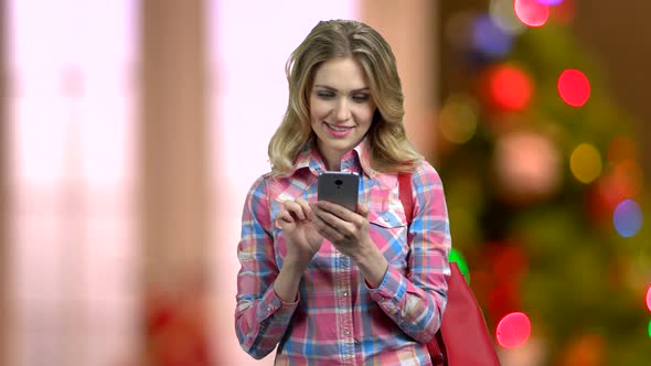 Woman Using Smartphone on Abstract Christmas Background