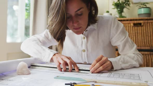 Caucasian female architect interior designer drawing working from home