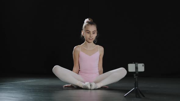 Teen Girl Dancer Gymnast Acrobat Ballerina Child Making Butterfly Stretch Exercise Sitting on Floor