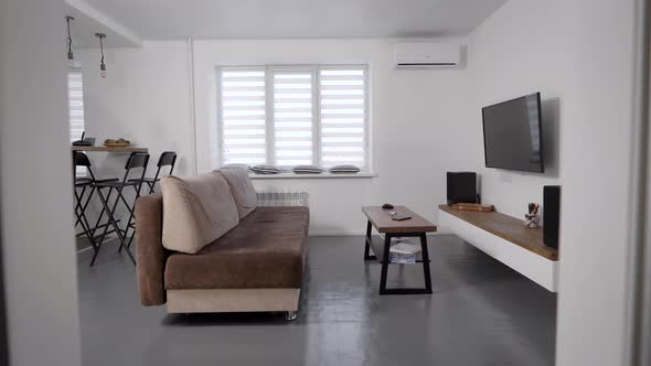 Stylish Modern Living Room. Apartments for Rent. TV and Sofa with a Coffee Table.