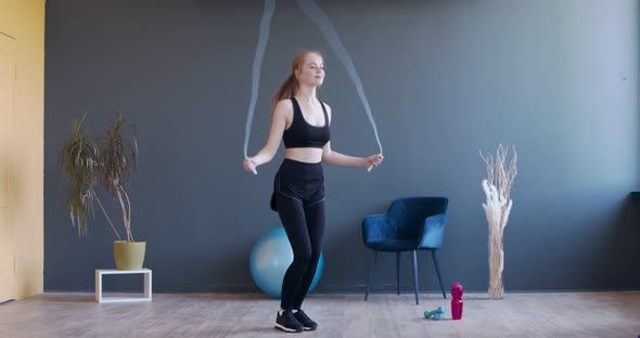 Young Sporty Woman Exercising with Skipping Rope