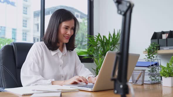 Asian young businesswoman working on a computer in the office with a new normal lifestyle concept.