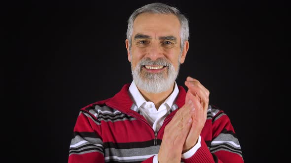 An Elderly Man Applauds and Smiles at the Camera - Black Screen Studio