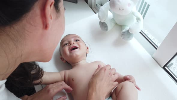 Joyful mother and little baby at home