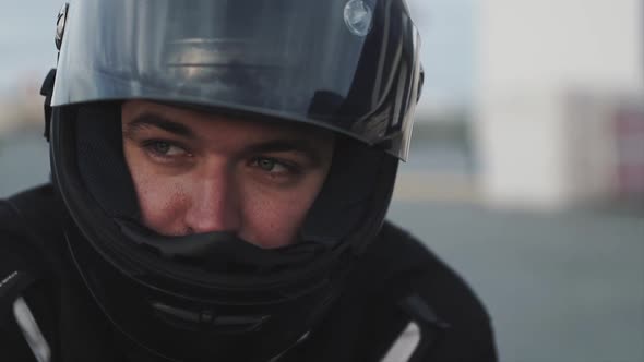 Portrait of Young Attractive Motorcyclist with Black Helmet on Street