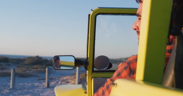 Happy caucasian man sitting in beach buggy by the sea