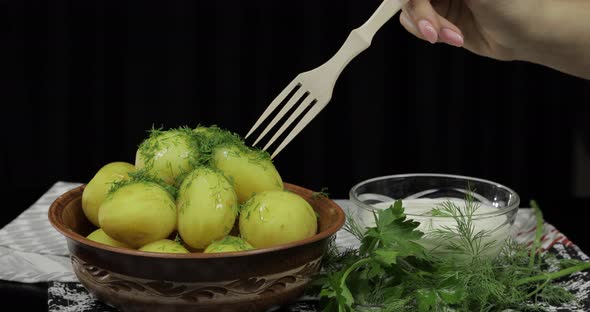 Woman's Hand Takes Boiled New Delicious Potato Using Wooden Fork