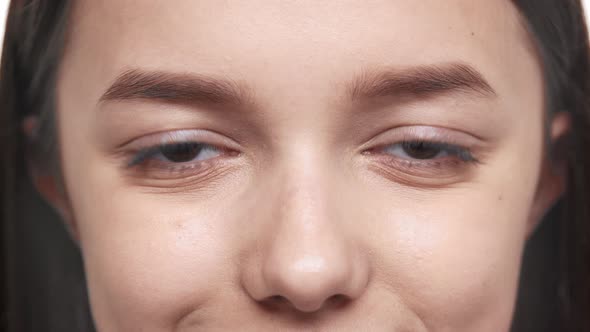 Extreme Closeup Portrait of Happy Teen Woman 20s with Clean Skin Looking Straight and Smiling Macro