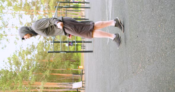 A Middleaged Man During an Outdoor Workout  He Jumps on a Rope Warming Up Before Training