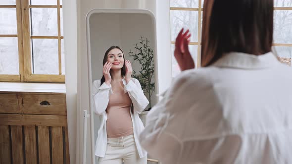 Cheerful Pregnant Woman Enjoys Reflection in Mirror Smiling