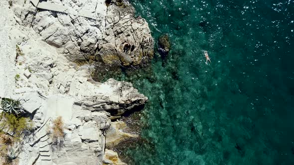 Aerial view of a person swimming in Primosten, Croatia.