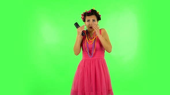 Woman with TV Remote in Her Hand, Switching on TV Bored and Is Very Scared. Green Screen