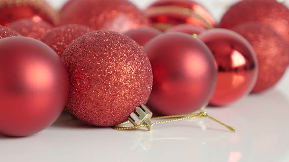 Golden strings on red Christmas baubles slow tilt 4K footage