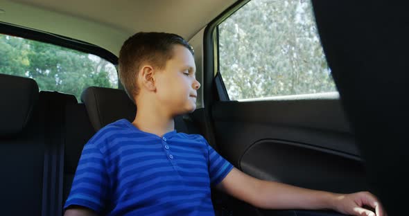 Boy relaxing in the back seat of car